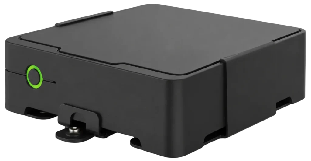 Angled view of the AXIS W800 System Controller showing black casing, green button, and mounting feet.