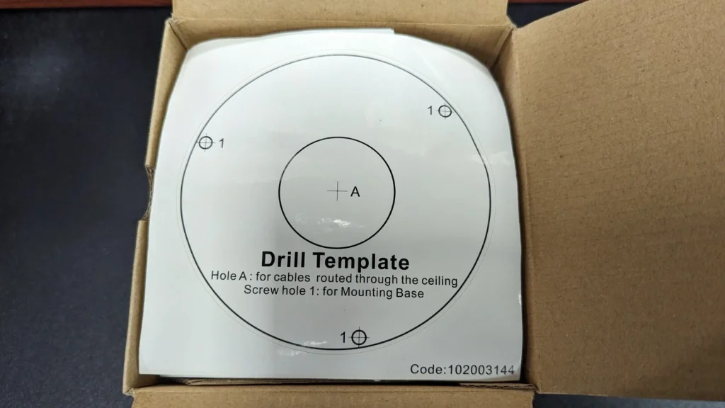 Drill template for precise dome camera installation showing screw and cable routing points.