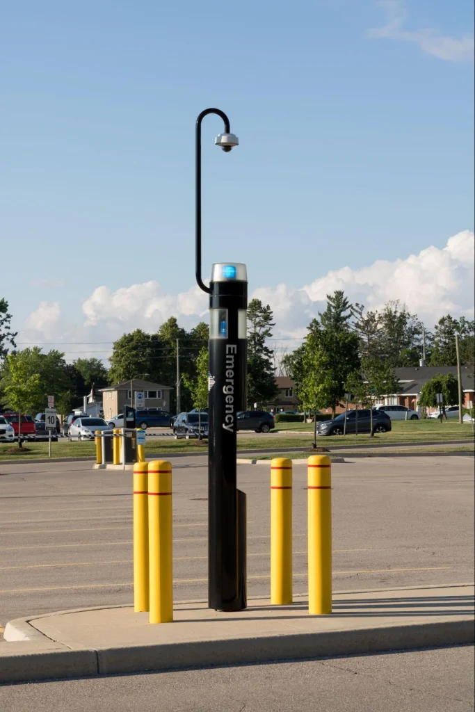 Emergency call box with blue light and CCTV for quick assistance and employee safety in the parking lot.