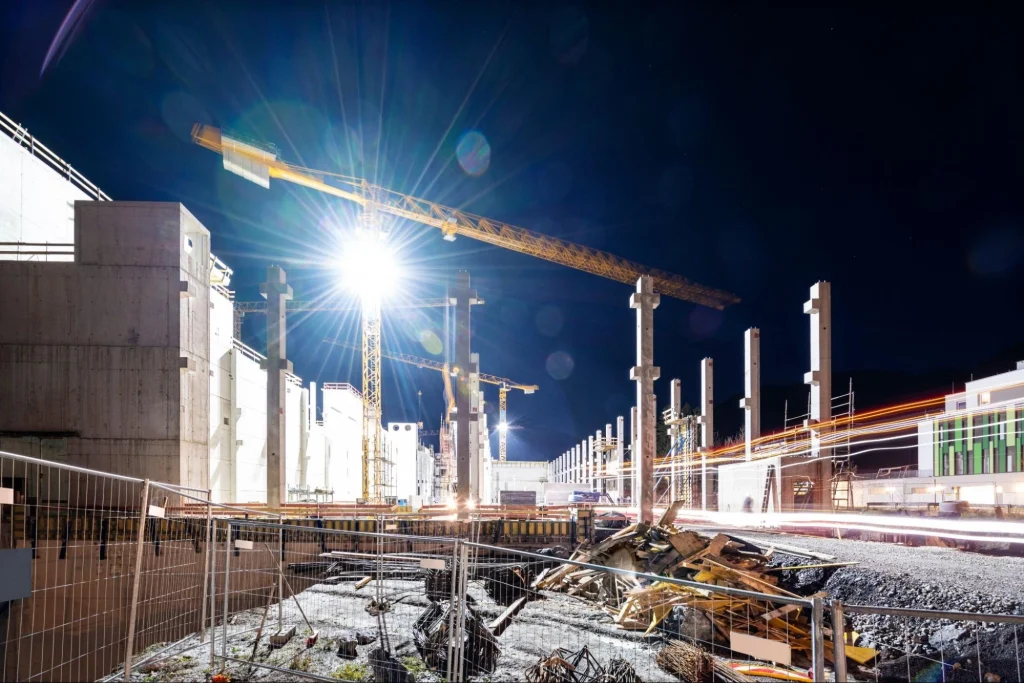 Chantier de nuit avec projecteurs et grues assurant la sécurité et réduisant les risques de vol