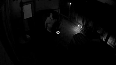 Séquence d'une caméra de surveillance nocturne montrant la vue floue d'une personne dans une zone faiblement éclairée.
