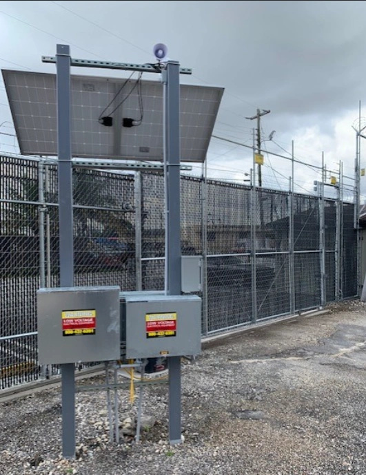 Un système de surveillance à énergie solaire est installé près de la clôture de la construction pour assurer la sécurité du site et prévenir les vols.