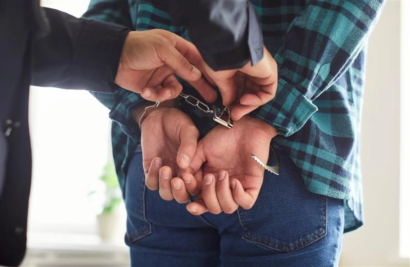 Agent de sécurité plaçant des menottes sur une personne lors d'une démonstration du protocole de sécurité d'un événement d'entreprise