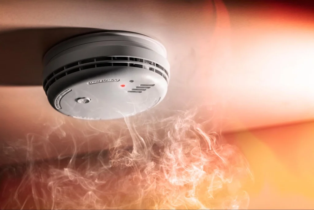Smoke detector detecting smoke in a room for fire safety.